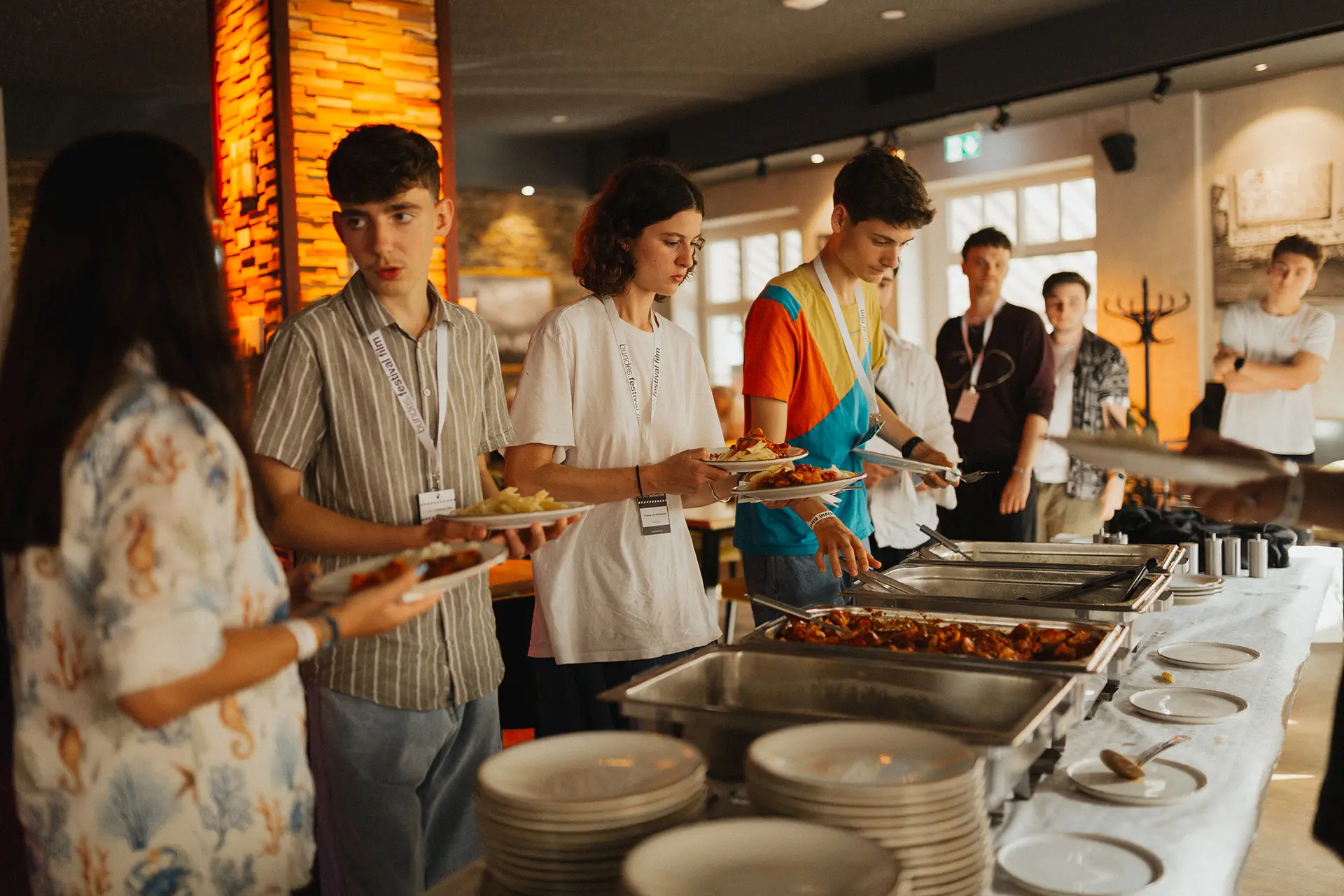 Mehrere Personen stehen am Buffet und unterhalten sich.