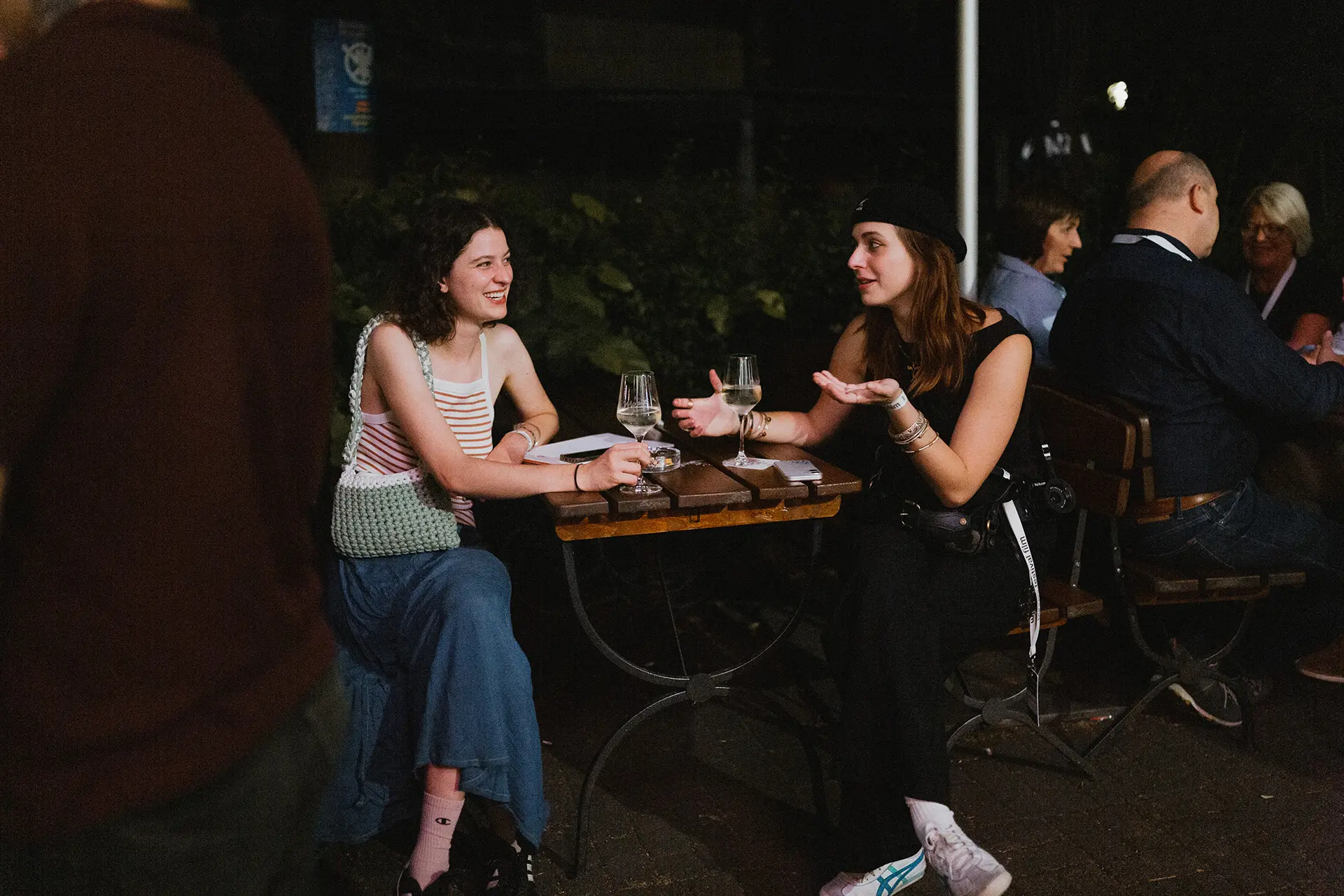 Zwei Personen unterhalten sich abends beim Festival.
